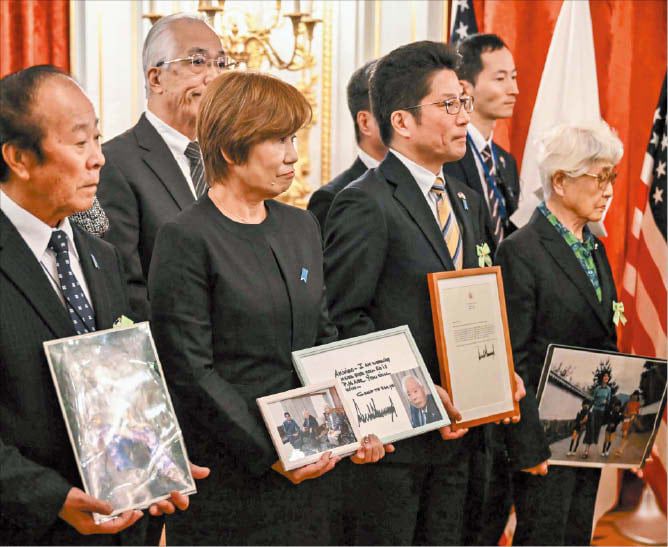 트럼프 만난 日 납북자 가족들  일본인 납북 피해자 가족들이 28일 미·일 정상회담이 열린 도쿄 모토아카사카 영빈관에서 피해자들의 사진을 들고 서 있다./AFP 연합뉴스
