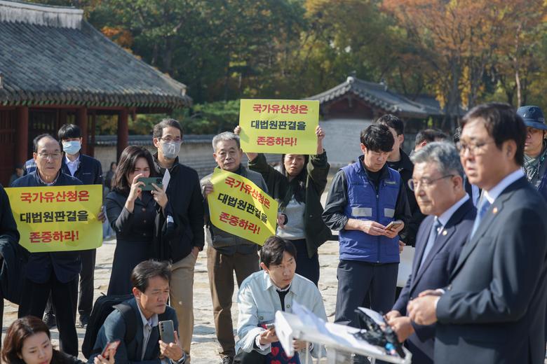 7일 오후 서울 종묘에서 최휘영(오른쪽) 문화체육관광부 장관과 허민(오른쪽 둘째) 국가유산청장이 서울시의 종묘 앞 개발 관련 대법원 판결에 대한 문체부, 국가유산청 입장 발표 기자회견을 열고 있는 가운데 세운4구역 주민들이 피켓 시위를 하고 있다. /장련성 기자