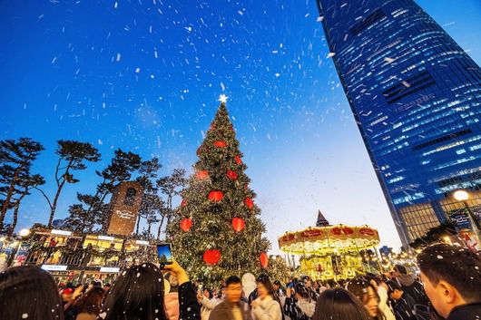 서울 잠실 ‘롯데타운 크리스마스 마켓’ 크리스마스 트리 주변에 인공 눈이 흩날리자 방문객들이 환호하며 인증샷을 찍고 있다. /양수열 영상미디어 기자