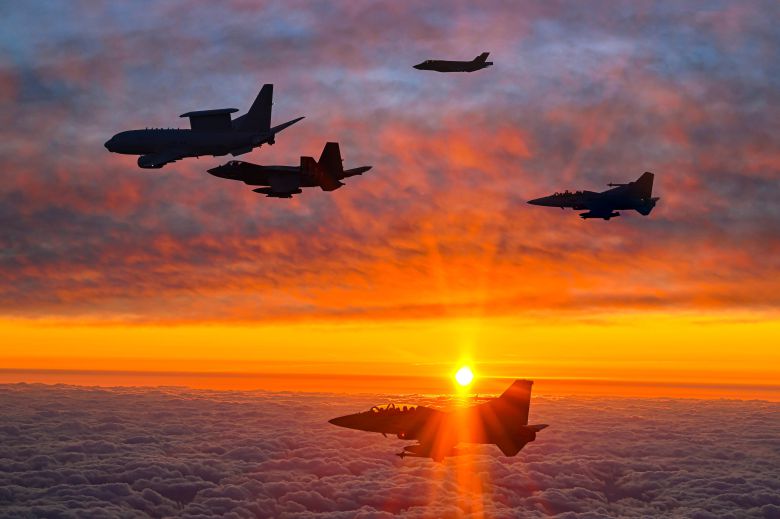 새해 첫 날인 1일 오전 안규백 국방장관이 탑승한 '하늘의 지휘소' 공군 항공통제기(E-737·왼쪽 첫째)가 떠오르는 태양 아래 KF-21 등 국산 전투기 편대의 엄호를 받으며 비행하고 있다. 안 장관은 이날 공군 항공통제기에 탑승해 한반도 전역의 군사대비태세를 점검했다. /국방부