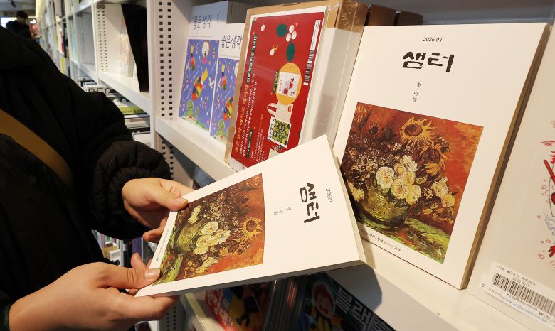 서울의 한 서점을 찾은 독자가 월간 '샘터' 2026년 1월호를 살펴보고 있는 모습. /연합뉴스