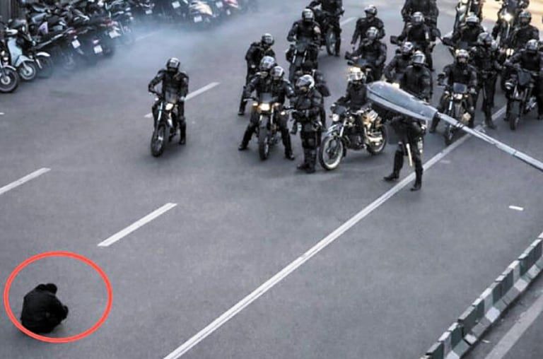 청년들의 대규모 반정부 시위가 확산 중인 이란 수도 테헤란에서 12월 31일 도로에 웅크리고 앉은 남성이 시위 진압을 위해 이동하던 경찰 오토바이 행렬을 막아서고 있다. 1989년 중국 천안문 시위 당시 전차를 맨몸으로 가로막았던 ‘탱크맨’을 연상시킨다는 반응도 나왔다./X