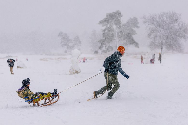 1월 3일(현지 시각) 네덜란드 룬옵잔트에 위치한 룬세 엔 드룬엔세 듄스 국립공원에서 한 남성이 아이를 썰매에 태워주고 있다. /EPA 연합뉴스