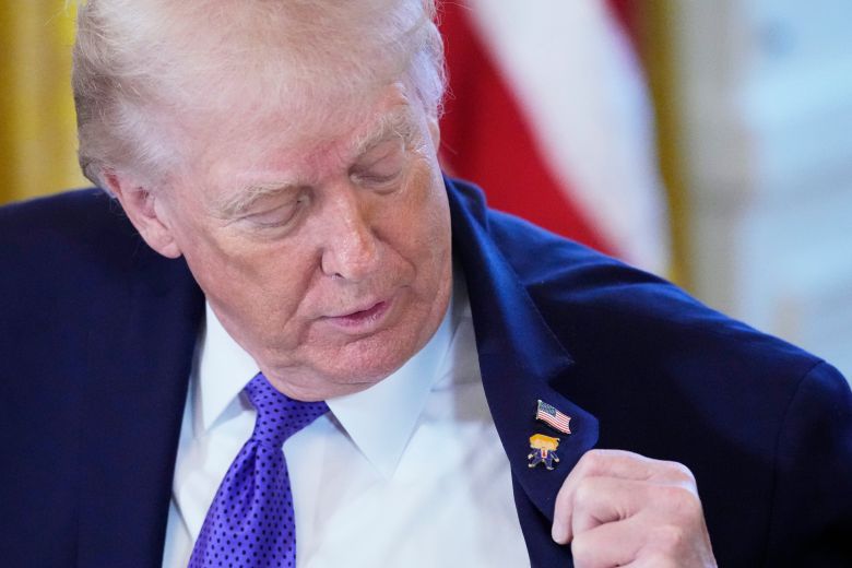 도널드 트럼프 미국 대통령이 9일 백악관에서 자신이 받았다는 '해피 트럼프' 배지를 보고 있다. /AP 연합뉴스