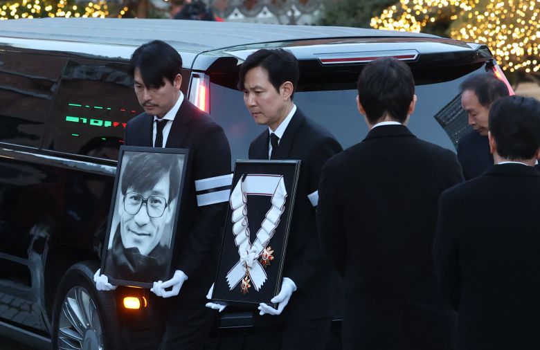 배우 정우성과 이정재가 故 안성기의 장례 미사를 위해 9일 오전 서울 중구 명동성당으로 들어서고 있다. 정우성은 고인의 영정을, 이정재는 금관문화훈장을 들고 있다. /뉴스1