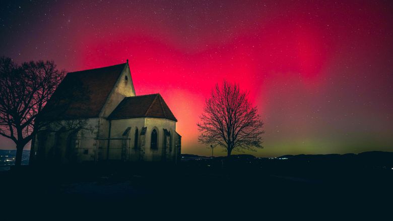19일 오스트리아 북부 바르트베르크 오프 데어 아이스트에 있는 교회 건물 위로 분홍색 오로라가 빛나고 있다./AFP 연합뉴스