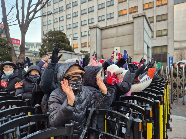 22일 서울 성북경찰서 유치장에서 출발한 전광훈 사랑제일교회 목사가 서울서부지검에 도착하자 지지자 60여 명이 양손을 들어 전 목사에게 인사하고 있다./권우석 기자