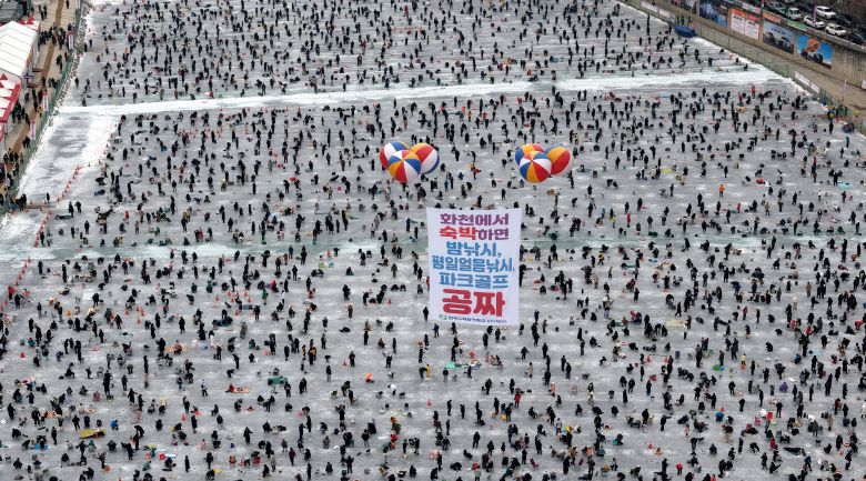지난 11일 강원도 화천군 ‘산천어 축제’ 현장을 공중에서 내려다본 모습. 전국에서 온 낚시객들이 꽁꽁 언 화천천에 구멍을 뚫고 얼음 낚시를 즐기고 있다. 이날 6만1324명이 현장을 찾았다./화천군 제공