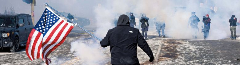 로이터 연합뉴스 미네소타 시위… 총구 앞에서도 놓지 못한 의지  24일 미국 미네소타주 미니애폴리스에서 강경 이민 단속에 항의하는 시위가 벌어진 가운데, 최루탄 연기 속에서 성조기를 든 한 남성이 무장한 연방 국경순찰대원들을 막아서고 있다. 이달 초 이민 단속 요원의 총격으로 37세 백인 여성이 숨진 데 이어, 이날 시위 진압 과정에서 백인 남성 알렉스 프레티(37)가 또다시 국경순찰대원의 총에 맞아 사망하면서 미 전역에서 이민 당국과 시민 사회 간 갈등이 고조되고 있다.