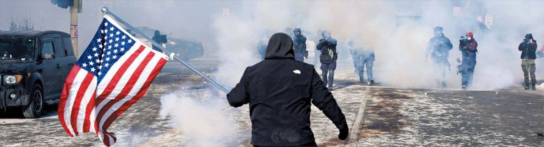 로이터 연합뉴스 미네소타 시위… 총구 앞에서도 놓지 못한 의지  24일 미국 미네소타주 미니애폴리스에서 강경 이민 단속에 항의하는 시위가 벌어진 가운데, 최루탄 연기 속에서 성조기를 든 한 남성이 무장한 연방 국경순찰대원들을 막아서고 있다. 이달 초 이민 단속 요원의 총격으로 37세 백인 여성이 숨진 데 이어, 이날 시위 진압 과정에서 백인 남성 알렉스 프레티(37)가 또다시 국경순찰대원의 총에 맞아 사망하면서 미 전역에서 이민 당국과 시민 사회 간 갈등이 고조되고 있다.