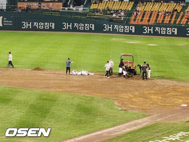 [OSEN=대전, 이상학 기자] 17일 KT-한화전 더블헤더 2차전이 열린 대전 한화생명이글스파크가 5회말 도중 내린 비로 경기가 중단된 지 3시간이 넘었다. 구장 관리 요원들이 정비 작업을 진행 중이다. /waw@osen.co.kr