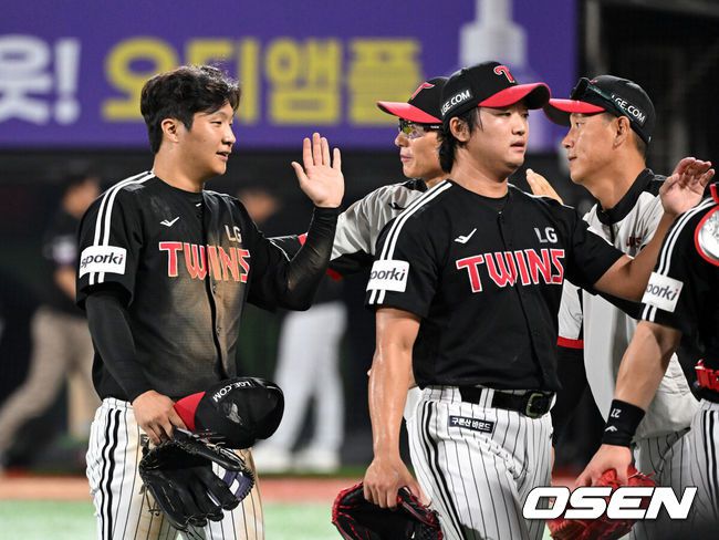LG 문보경과 고우석이 염경엽 감독과 승리의 기쁨을 나누고 있다. / OSEN DB