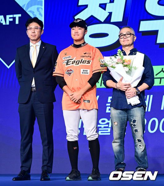 [OSEN=지형준 기자] 11일 오후서울 잠실 롯데호텔 월드에서 2025 KBO 신인 드래프트가 열렸다.2025 KBO신인 드래프트는 전면 드래프트 방식으로 진행된다. 지명은 1라운드부터 11라운드까지 이뤄지며, 2023년도 구단 순위의 역순인 키움-한화-삼성-롯데-KIA-두산-NC-SSG-KT-LG 순서로 실시된다.전주고 정우주가 한화에 지명되며 손혁 단장, 아버지와 포즈를 취하고 있다. 2024.09.11 / jpnews@osen.co.kr
