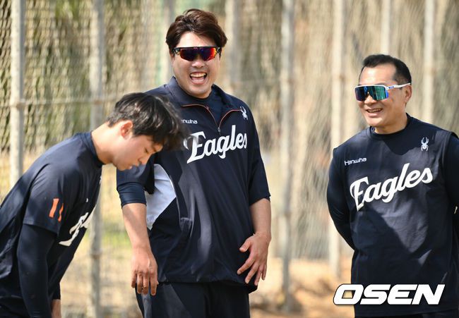 [OSEN=오키나와(일본), 조은정 기자] 한화 류현진이 훈련 중 엄상백, 장세홍 트레이닝코치(오른쪽)와 이야기하며 미소를 짓고 있다. 2025.02.27 /cej@osen.co.kr