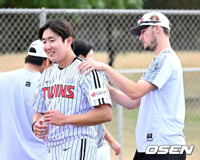[OSEN=애리조나(미국), 이대선 기자] 15일(한국시간) 미국 애리조나주 스코츠데일 인디언스쿨 파크 베이스볼필드에서 LG 트윈스의 1차 스프링캠프가 진행됐다. LG 캠프 초청선수 코엔 윈이 손주영의 어깨를 주무르고 있다. 2025.02.15 / sunday@osen.co.kr