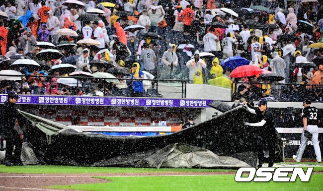 [OSEN=대전, 지형준 기자] 15일 대전 한화생명볼파크에서 2025 신한 SOL Bank KBO리그 한화 이글스와 LG 트윈스의 경기가 열렸다.이날 한화는 문동주, LG는 송승기를 선발로 내세웠다.5회말 1사 2루에서 한화 채은성 타석에 폭우로 경기가 중단되고 있다. 그라운드 관계자가 급히 방수포를 깔고 있다. 2025.06.15 /jpnews@osen.co.kr