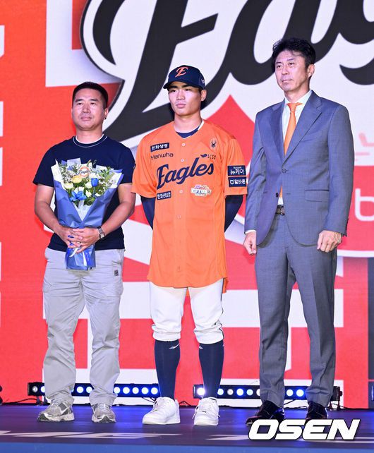 [OSEN=이대선 기자] 17일 오후 7일 오후 서울 롯데호텔 월드에서 ‘2026 KBO 신인 드래프트’가 열렸다. 한화에 지명된 유신고 오재원이 아버지, 손혁 단장과 기념촬영을 하고 있다. 2025.09.17 /sunday@osen.co.kr