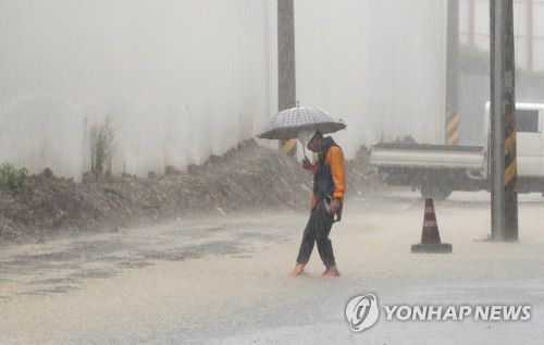 '억수'(광주=연합뉴스) 박철홍 기자 = 광주·전남에 장마전선의 영향으로 많은 비가 내린 29일 오전 광주 북구 중흥동의 주택가에 아파트 공사 현장에서 퍼낸 빗물이 넘쳐흘러 관계자가 배수로를 점검하고 있다. 2020.7.29 pch80@yna.co.kr