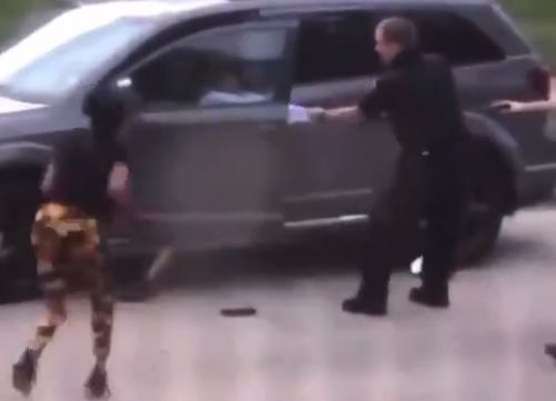 경찰이 총을 쏜 후 한 여성이 다가와 팔짝팔짝 뛰고 있는 모습[트위터 영상 갈무리. 재판매 및 DB 금지]