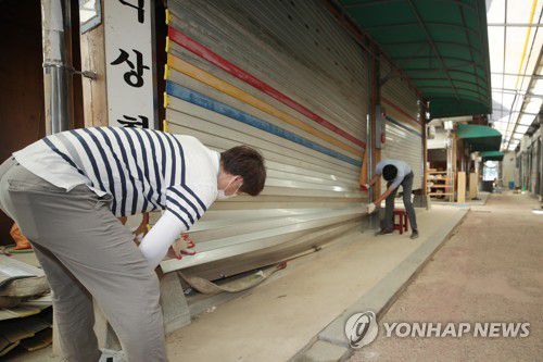 태풍 소식에 구례 수해지역 또 '비상'(구례=연합뉴스) 천정인 기자 = 25일 오전 전남 구례군 구례읍 구례 오일시장에서 군 관계자들이 제8호 태풍 '바비'에 대비해 침수 피해로 망가진 상점 철문을 점검하고 있다. 2020.8.25 iny@yna.co.kr