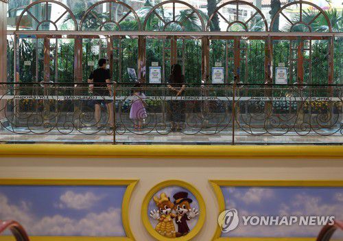 주말 나들이 막은 코로나(서울=연합뉴스) 신준희 기자 = 16일 오후 코로나19 확진자가 방문한 것으로 확인돼 폐장된 잠실 롯데월드를 찾은 시민들이 놀이공원 내부를 들여다보고 있다. 2020.8.16 hama@yna.co.kr