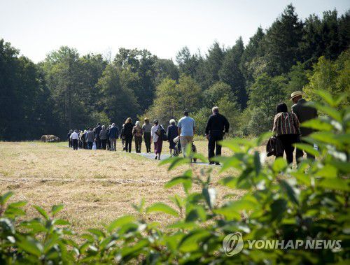 지난해 열린 추모 행사서 펜실베이니아 섕크스빌의 여객기 추락 현장을 둘러보는 유족들[UPI=연합뉴스]