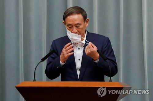 (도쿄 로이터=연합뉴스) 오는 16일 총리에 취임하는 스가 요시히데 관방장관이 14일 관방장관 자격으로 마지막 기자회견을 하기 위해 마스크를 벗고 있다. sungok@yna.co.kr