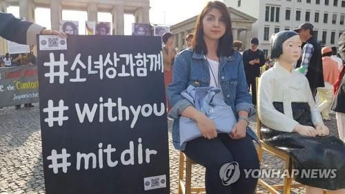 베를린에서 소녀상과 함께 사진을 찍는 시민(베를린=연합뉴스) 이광빈 특파원 = 지난해 8월 14일(현지시간) 독일 수도 베를린의 브란덴부르크문에서 열린 일본군 위안부 기림일 행사에서 '평화의 소녀상' 옆에 앉은 독일 시민. 2019.8.14