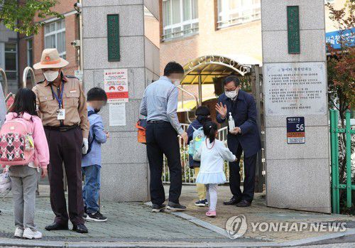 '어서와요'지난 12일 오전 서울 마포구 창천초등학교에서 초등학생과 유치원생들이 등교를 하며 발열체크와 손소독을 하고 있다. [연합뉴스 자료사진]