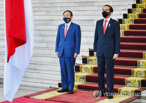 양국 국가 듣는 일본-인도네시아 정상(자카르타 AP=연합뉴스) 20일(현지시간) 인도네시아를 방문한 스가 요시히데(왼쪽) 일본 총리가 수도 자카르타 외곽 보고르 대통령궁에서 열린 환영식에서 조코 위도도 인도네시아 대통령과 함께 나란히 서서 양국 국가 연주를 듣고 있다. 스가 총리는 취임 후 첫 해외 순방지로 동남아를 선택해 전날 베트남 수도 하노이를 먼저 방문하고 이날 인도네시아에 도착했다. [인도네시아 대통령궁 제공] leekm@yna.co.kr