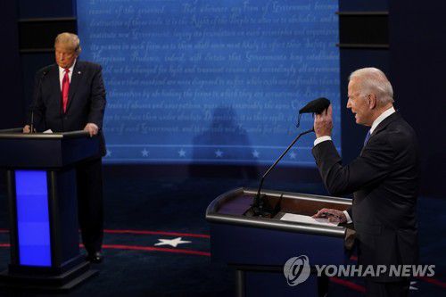토론에서 메모하는 트럼프 대통령과 마스크를 들어 보이는 바이든 후보 [AP=연합뉴스]
