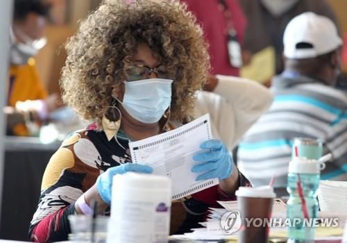 미 대선 투표용지 점검하는 조지아 선거사무원    (애틀랜타 AFP=연합뉴스) 미국 대선 개표 3일째인 5일(현지시간) 조지아주 애틀랜타의 '스테이트팜 아레나'에 마련된 개표장에서 풀턴 카운티의 선거사무원이 투표용지를 점검하고 있다. 도널드 트럼프 대통령 선거캠프는 조지아주의 개표 과정에 문제가 있다며 개표 중단 소송을 제기했으나 이날 1심 법원은 이를 기각했다.