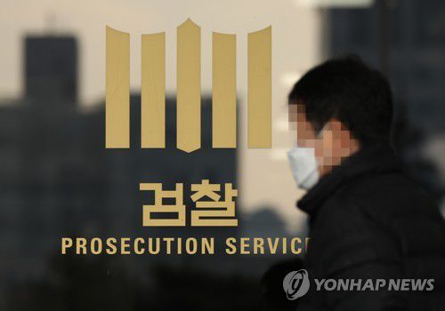 윤석열 총장 정직처분 집행정지 재판 D-Day(서울=연합뉴스) 김도훈 기자 = 22일 오전 서울 서초구 서울중앙지검 유리창에 붙은 검찰 로고 앞으로 관계자가 지나고 있다. superdoo82@yna.co.kr