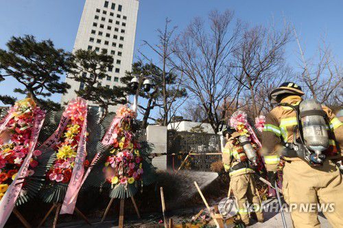 대검 앞 방화 소동(서울=연합뉴스) 류영석 기자 = 지난 5일 오전 서울 서초구 대검찰청 앞에서 한 남성이 윤석열 검찰총장 응원화환에 불을 붙이자 119 소방대원들이 출동해 잔불을 끄고 있는 모습. ondol@yna.co.kr