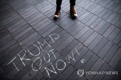 뉴욕 길바닥에 적힌 '트럼프 당장 퇴진하라' 글귀(뉴욕 로이터=연합뉴스) 도널드 트럼프 미국 대통령의 극렬 지지자들이 워싱턴DC 연방의회 의사당을 점거하는 사태가 벌어진 다음 날인 7일(현지시간) 미국 뉴욕시 브루클린 바클레이스 센터 근처 길바닥에 "트럼프, 당장 꺼져!"라고 적힌 글귀가 보이고 있다. knhknh@yna.co.kr