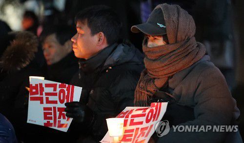 추위 속 촛불집회(서울=연합뉴스) 하사헌 기자 =  2016년 12월 1일 오후 쌀쌀해진 날씨 속에 서울 중구 파이낸스센터 앞에서 열린 촛불집회에서 방한복을 입은 시민들이 박 대통령 퇴진을 요구하는 촛불을 들고 있다.  [연합뉴스 자료사진]