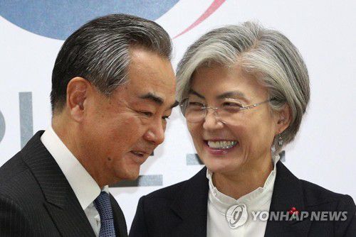 밝은 표정의 한중 외교장관강경화 외교부 장관과 왕이 중국 외교담당 국무위원 겸 외교부장이 2019년 12월 4일 오후 서울 종로구 외교부에서 인사를 나눈 뒤 자리로 이동하고 있다. [연합뉴스 자료사진]