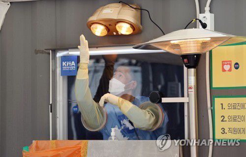 코로나19 1년, 끝나지 않은 시간(서울=연합뉴스) 김인철 기자 = 오는 20일 국내에서 신종 코로나바이러스 감염증(코로나19) 첫 확진자가 나온 지 꼭 1년째가 되는 가운데 19일 오후 서울광장에 마련된 임시 선별진료소에서 의료진이 난로로 손을 녹이고 있다. 2021.1.19 yatoya@yna.co.kr