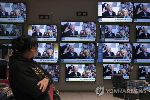 이스라엘의 전자제품 매장에서 직원이 바이든 미국 대통령 취임식 중계를 보고 있다[AP=연합뉴스]