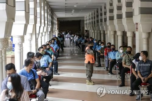 코로나19 백신 접종 차례 기다리는 인니 상인들[EPA=연합뉴스]