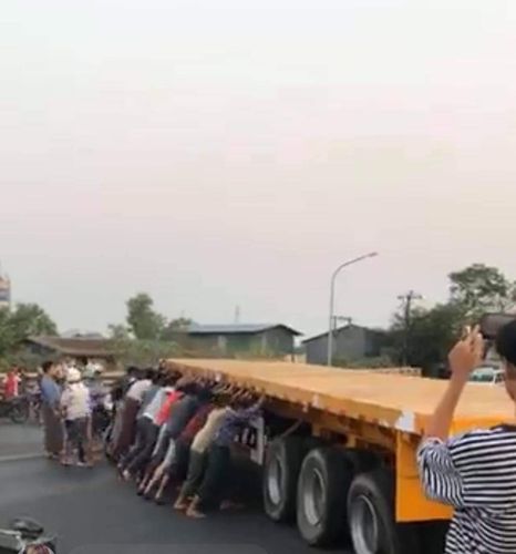 다리를 가로막고 있던 대형 트레일러 짐칸을 시민들이 밀고 있는 모습. [트위터 캡처. 재판매 및 DB 금지]