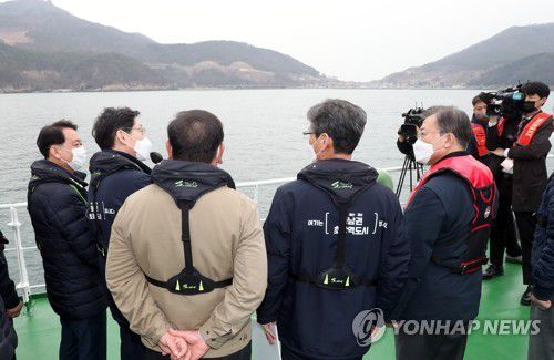가덕도 공항 예정지 선상 시찰하는 문 대통령(부산=연합뉴스) 최재구 기자 = 문재인 대통령이 25일 부산에서 열린 '동남권 메가시티 구축 전략 보고'에 참석, 가덕도 공항 예정지를 어업지도선을 타고 선상 시찰하며 김경수 경남도지사의 발언을 듣고 있다.  2021.2.25 jjaeck9@yna.co.kr