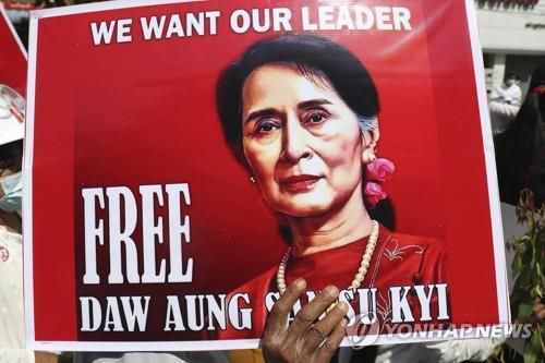 한 시위 참여자가 '아웅산 수치를 석방하라'는 포스터를 들고 있다. 2021.2.22[AP=연합뉴스]