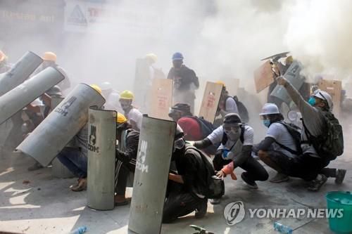 시위대가 양곤 시내에서 방패 등으로 경찰의 최루탄을 막는 모습. 2021.2.28[로이터=연합뉴스. 재판매 및 DB 금지]