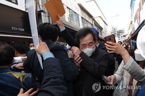 달걀 봉변당한 이낙연 대표(춘천=연합뉴스) 양지웅 기자 = 더불어민주당 이낙연 대표가 5일 오후 강원 춘천시 중앙시장을 방문하던 도중 레고랜드 반대 단체 관계자가 달걀을 던져 몸을 피하고 있다. 2021.3.5 yangdoo@yna.co.kr