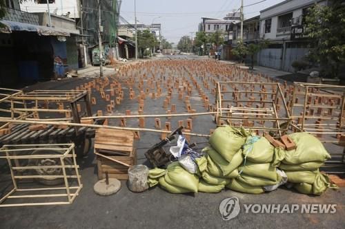 만달레이 도로에 군경 진입을 막기 위한 바리케이드와 벽돌이 놓여있다. 2021.3.10[EPA=연합뉴스]