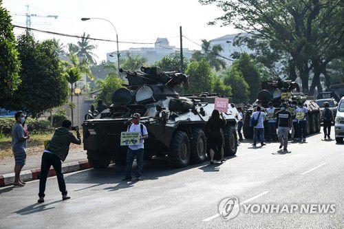 군 장갑차 주위에서 쿠데타 항의하는 미얀마 시위대(양곤 AFP=연합뉴스) 미얀마 최대 도시인 양곤 중심가에 배치된 군 장갑차 주변에서 15일(현지시간) 시민들이 쿠데타에 항의하는 시위를 벌이고 있다. 미얀마 군정은 전날 장갑차를 탄 병력을 양곤 시내로 이동시키고 인터넷을 사실상 전면 차단했다. 현지 언론은 쿠데타 항의 시위에 대한 군정의 강경 진압이 임박한 것으로 보인다고 전했다. sungok@yna.co.kr