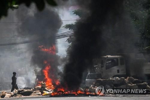 군인들이 양곤 시내에 설치된 바리케이드에 불을 지르고 있다. 2021.3.19[AFP=연합뉴스]