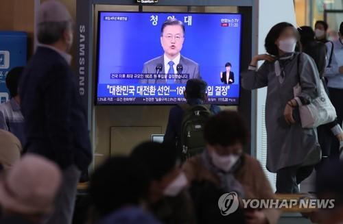 문재인 대통령 취임 4주년 특별연설 지켜보는 시민들(서울=연합뉴스) 임헌정 기자 = 10일 서울역에서 시민들이 문재인 대통령의 취임 4주년 특별연설을 TV로 시청하고 있다. kane@yna.co.kr