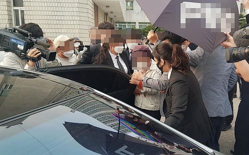 법정 나온 윤석열 장모(의정부=연합뉴스) 김도윤 기자 = 요양급여 부정수급 혐의를 받는 윤석열 전 검찰총장의 장모 최모씨가 31일 법정에서 나와 차에 타고 있다. 최씨가 카메라에 노출되지 않도록 윤 전 총장의 지지자들이 우산으로 가리는 등 소란이 일자 법정 경위들이 보호하고 있다. 2021.5.31 kyoon@yna.co.kr